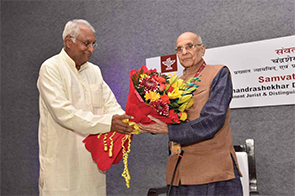 Vishwanath Tiwari felicitating Dr. C.S. Dharmadhikari with flowers