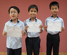 Primary students proudly pose with the certificates